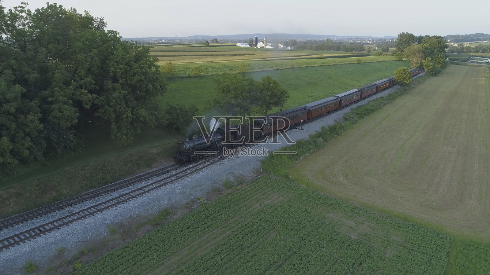 鸟瞰图的古董蒸汽机车吹烟和蒸汽旅行通过农田照片摄影图片
