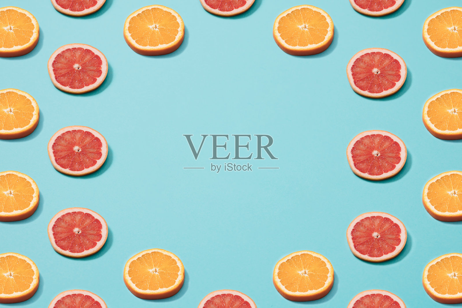 蓝色背景下的橘片和葡萄柚片。最小的模式。副本的空间。照片摄影图片