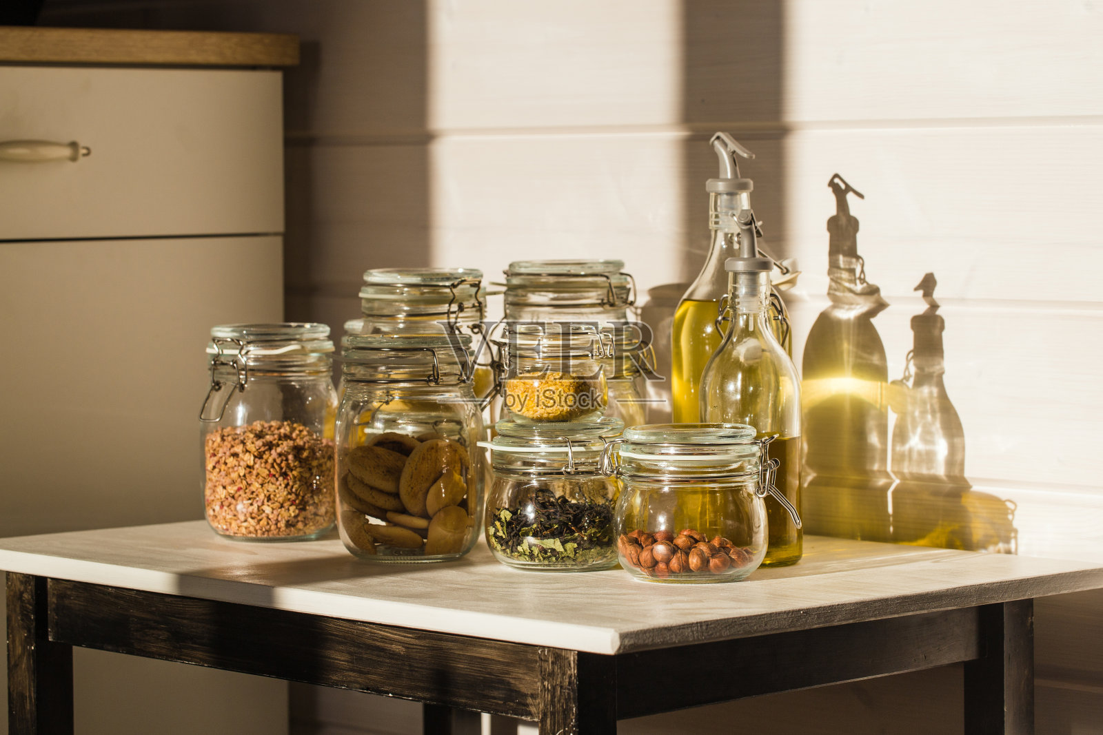 各种各样的生谷物,谷物和意大利面装在玻璃罐里放在木桌上。健康烹饪、清洁饮食、零浪费理念照片摄影图片