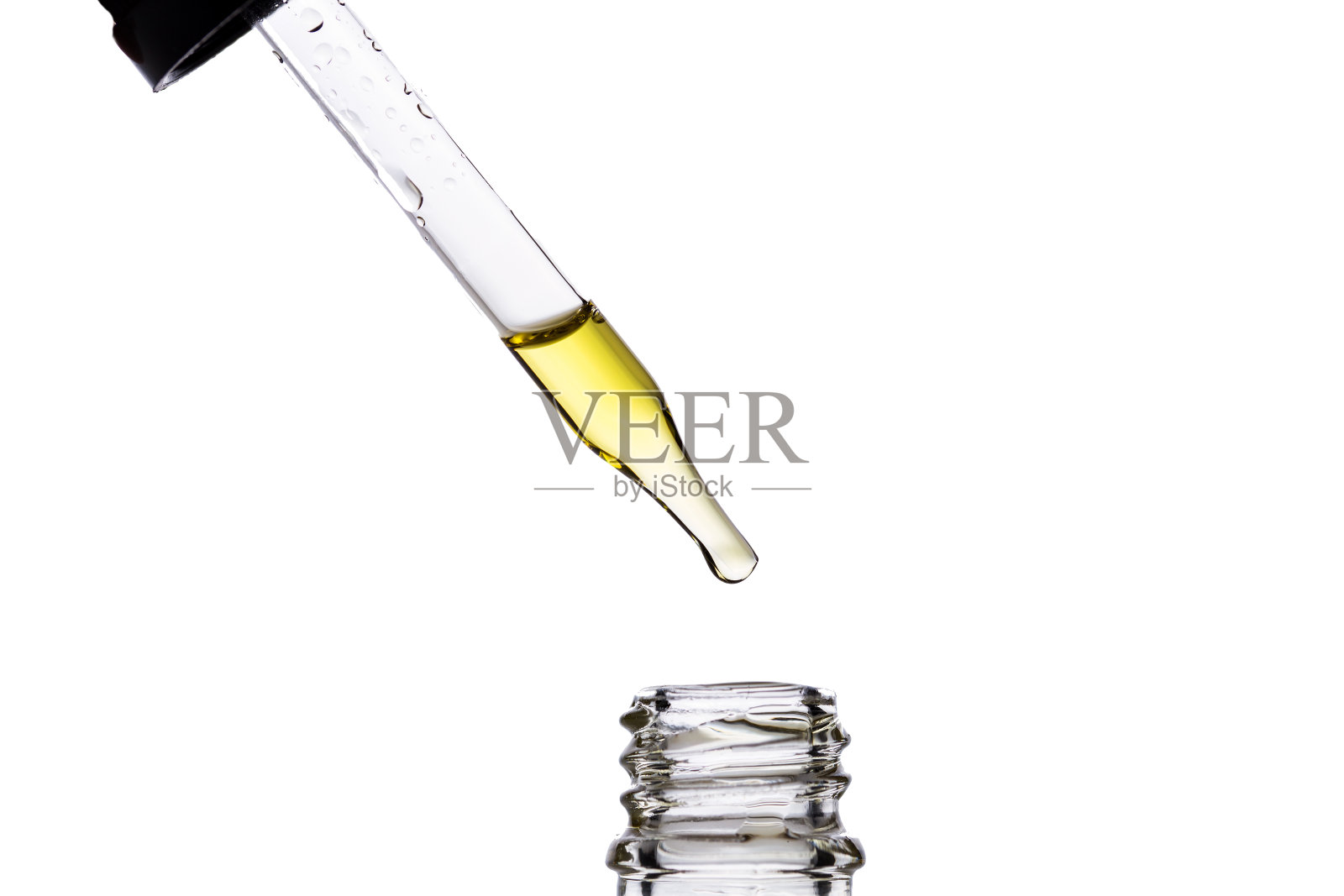 按摩油在一个玻璃瓶与移液管在一个白色孤立的背景照片摄影图片