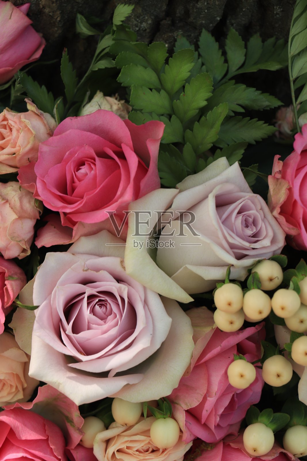 粉色和紫色的玫瑰点缀在婚礼的中心装饰品上照片摄影图片