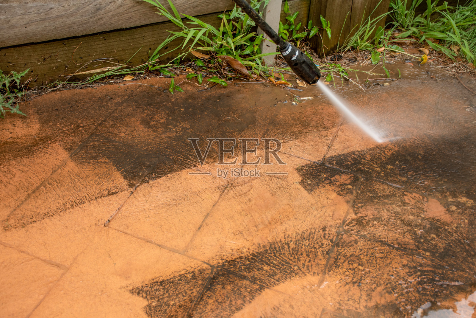 有选择性的重点。用高压清洗机清洗后院地砖。照片摄影图片
