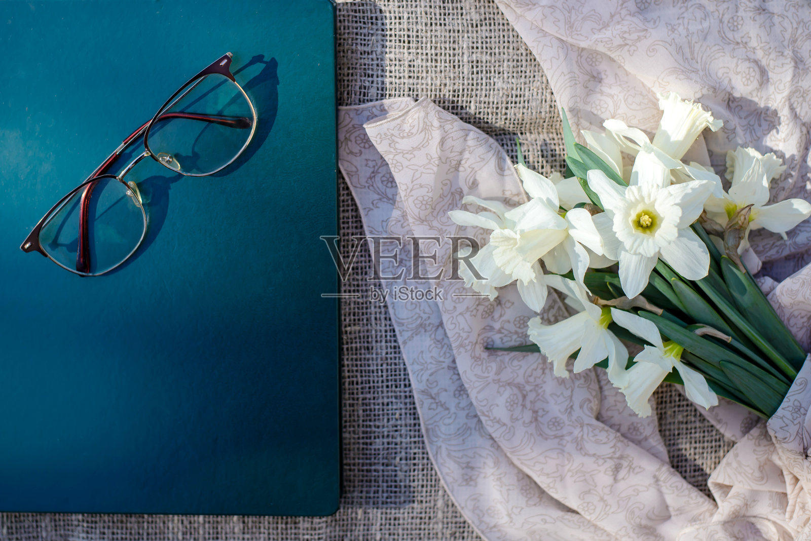 一束白色的水仙花,书和眼镜照片摄影图片