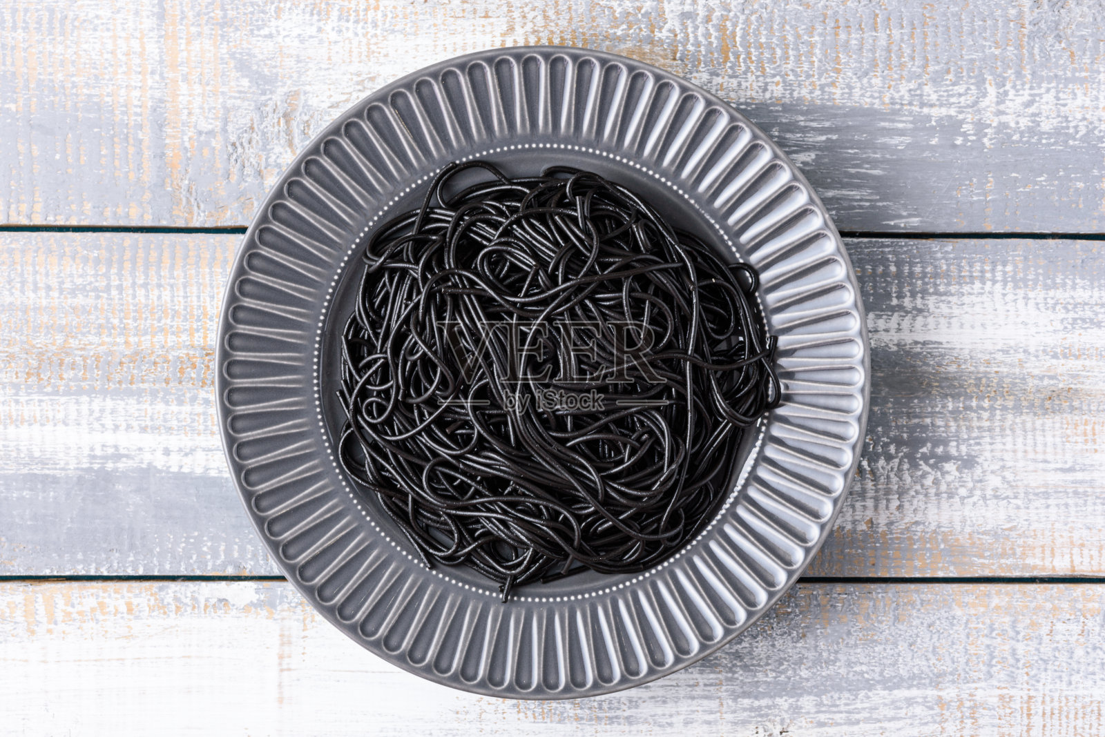 黑色素食意大利面,墨鱼墨,灰色板,浅木背景照片摄影图片