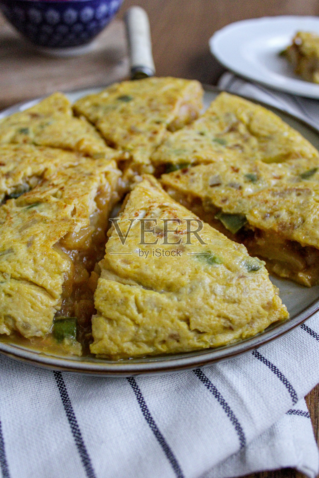 西班牙玉米饼土豆煎蛋卷俯视图。洋葱蛋和土豆做成的切片圆煎蛋卷。装盘和准备服务。照片摄影图片