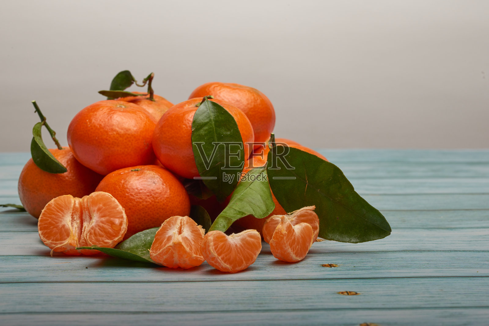 蓝色的木桌上放着几个桔子照片摄影图片