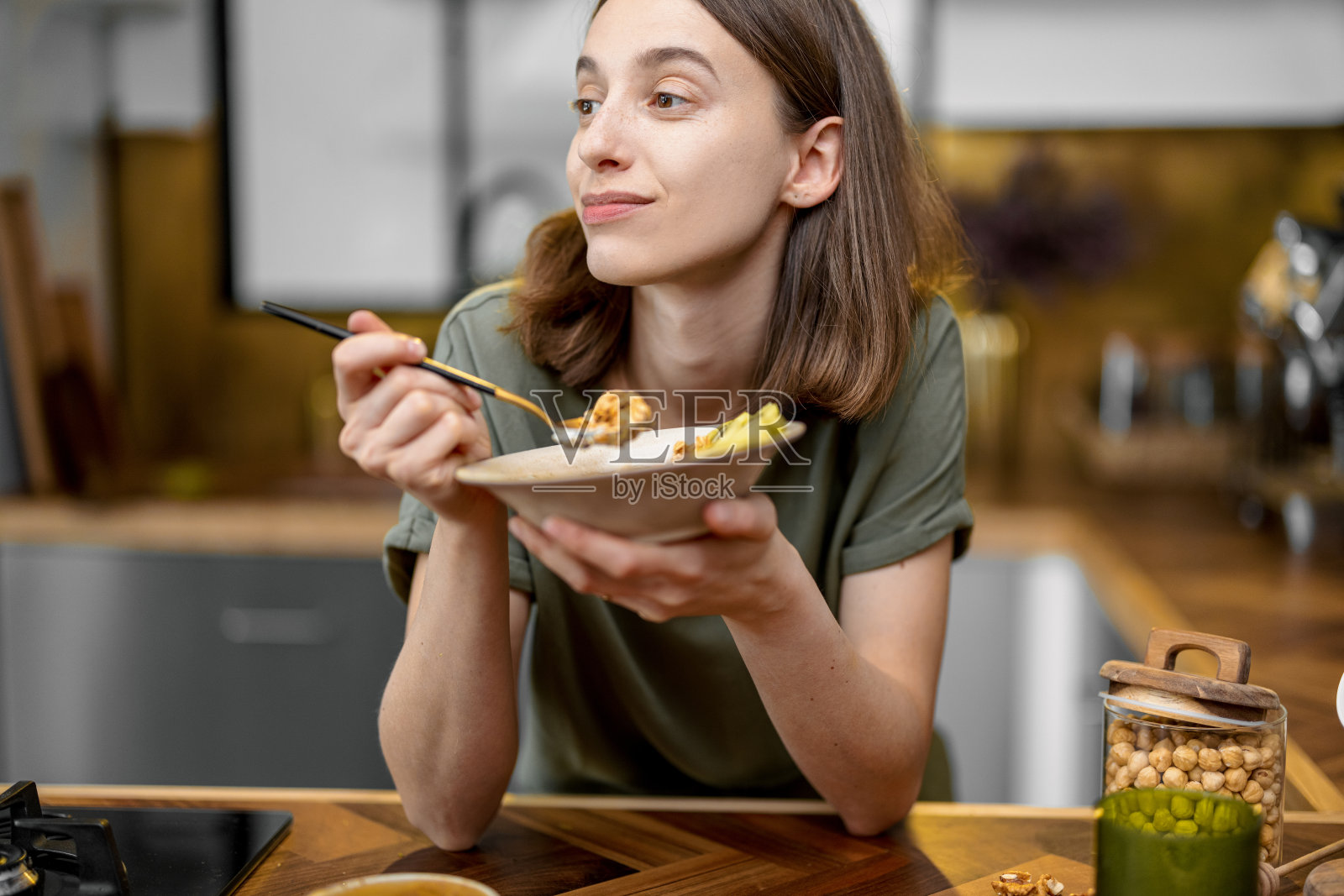 早上在厨房端着咖啡和电话的女人照片摄影图片