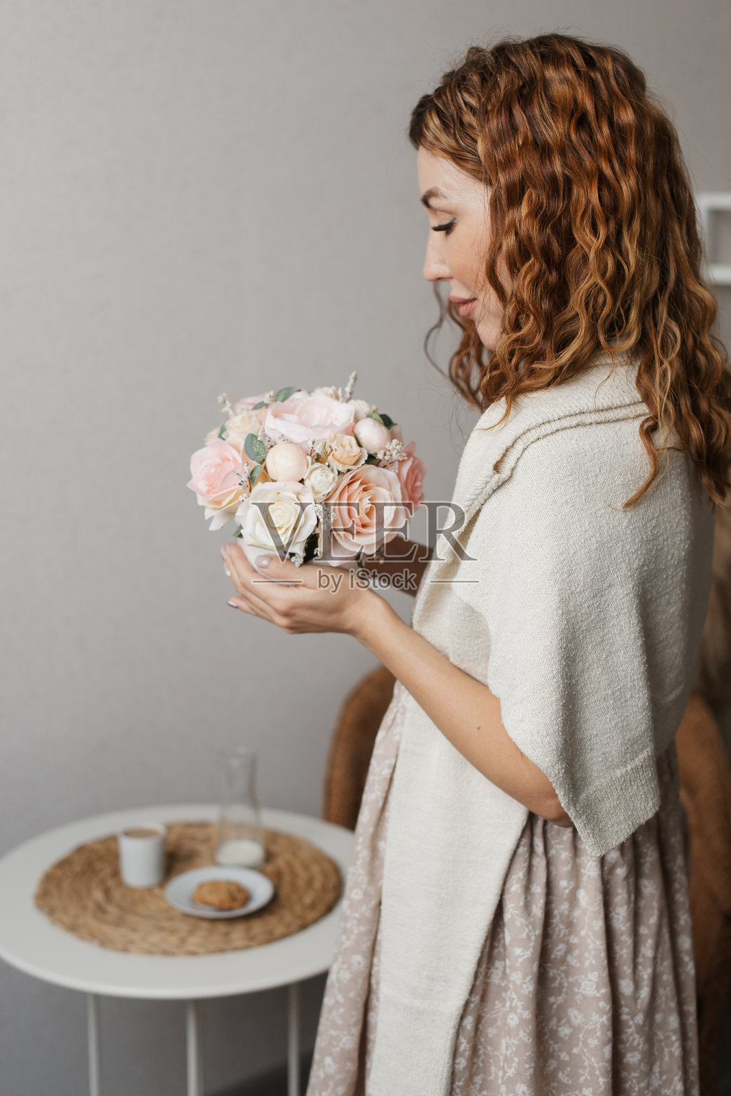 一个穿着裙子的年轻女子手中拿着一束精致的鲜花照片摄影图片