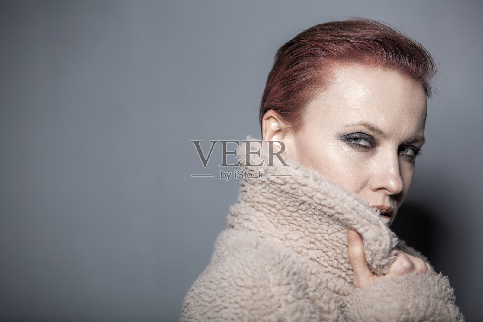 漂亮的红发女人穿着人造毛皮大衣照片摄影图片