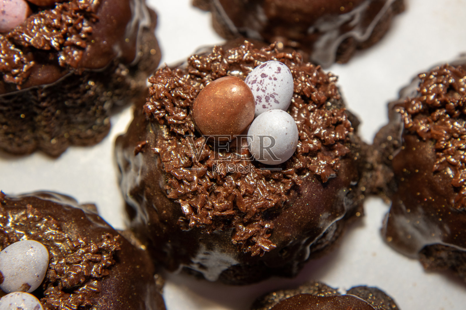 精选复活节巧克力巢蛋糕,上面有三个迷你巧克力蛋放在白色盘子上照片摄影图片