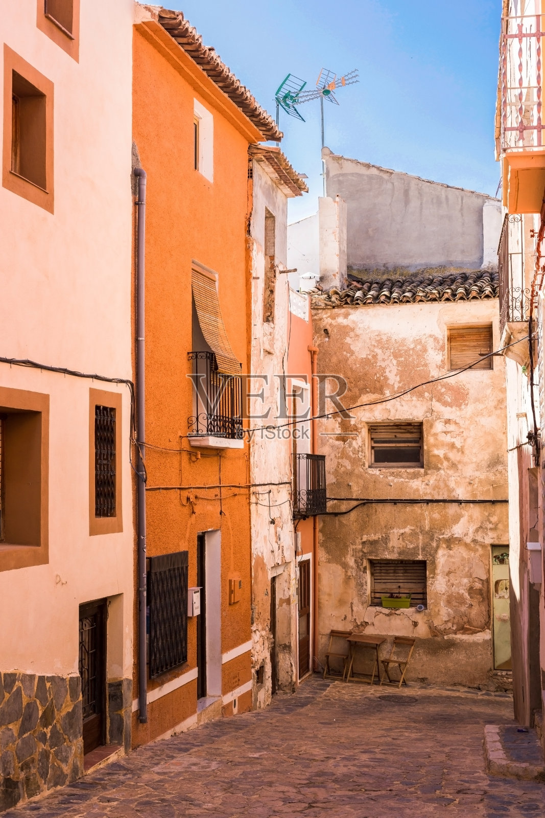 西班牙Costa Blanca Finestrat,老城狭窄的街道,五颜六色的房子,破旧的灰泥和鹅卵石路照片摄影图片