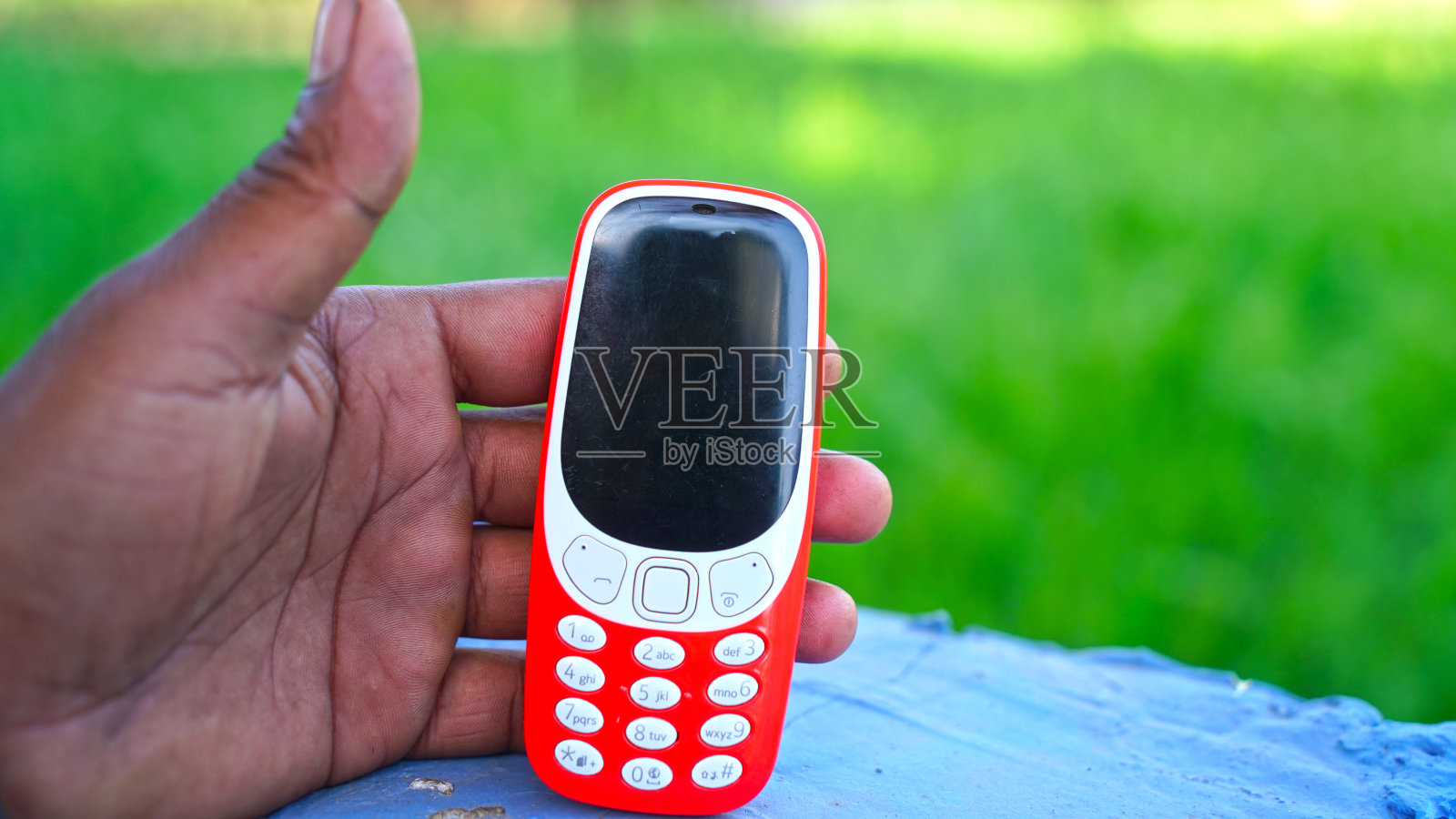 现代2G键盘手机概念。键盘上的手机查看绿色背景。旧的手机概念。照片摄影图片