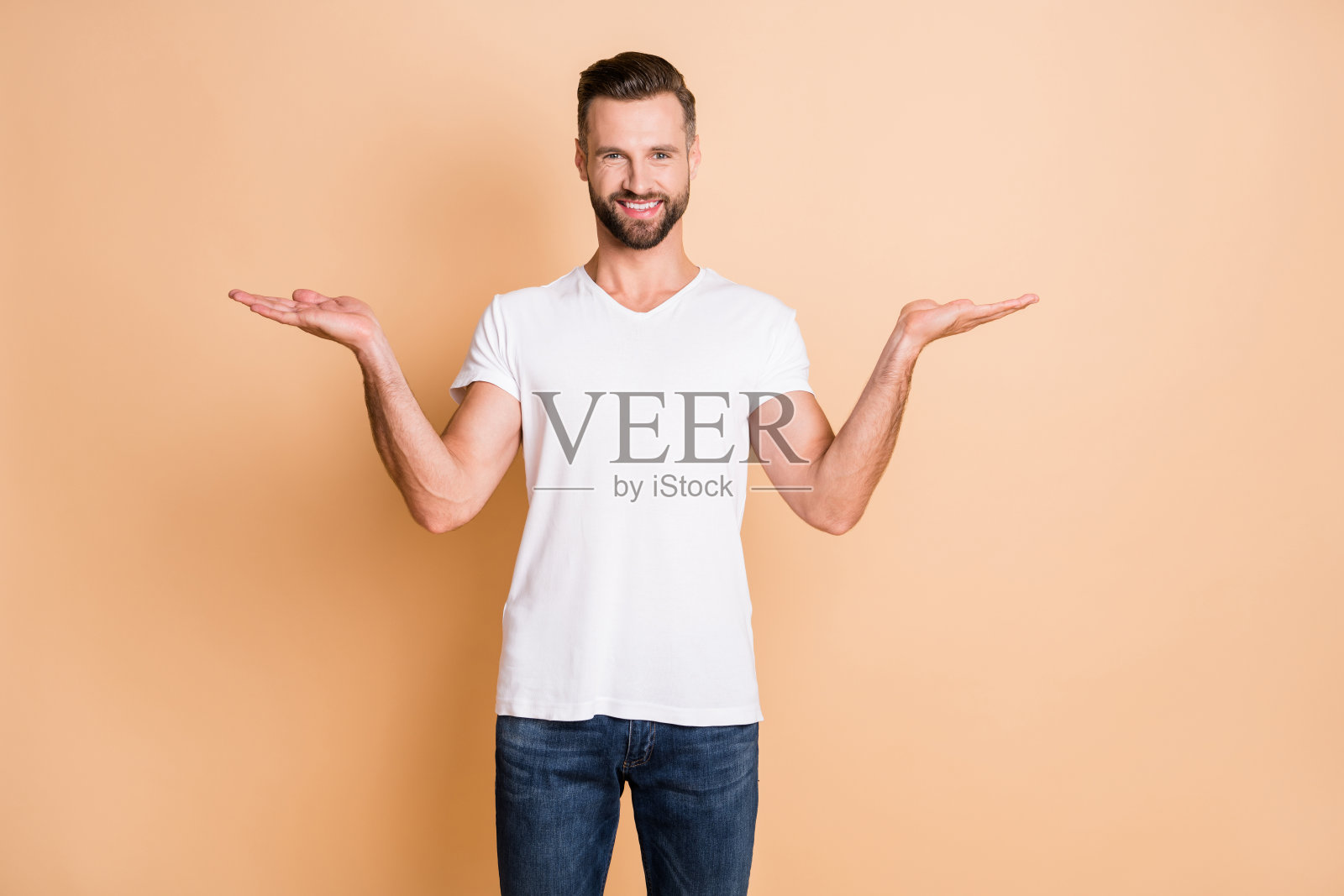 肖像有吸引力的愉快的家伙拿着手掌复制空的地方广告孤立在米色柔和的颜色背景照片摄影图片