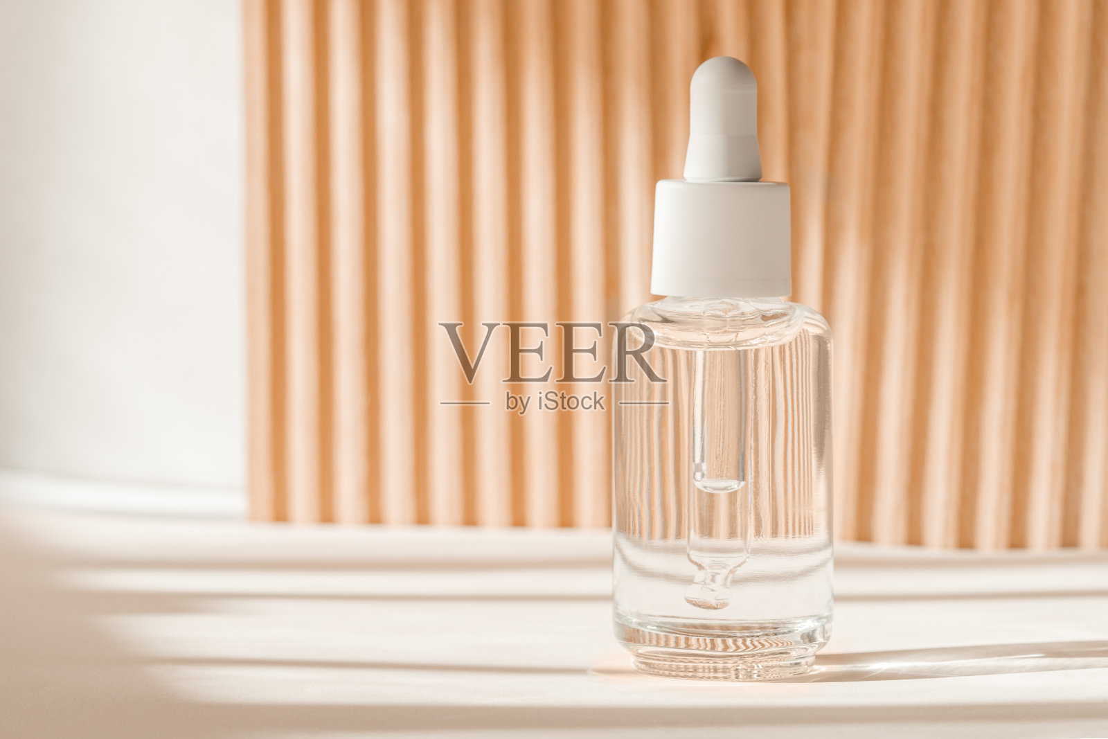血清化妆瓶,透明质酸在棕色背景。含肽和胶原蛋白的血清化妆品。化妆展柜,装饰艺术,自然阴影。商业、现代的品牌包装照片摄影图片