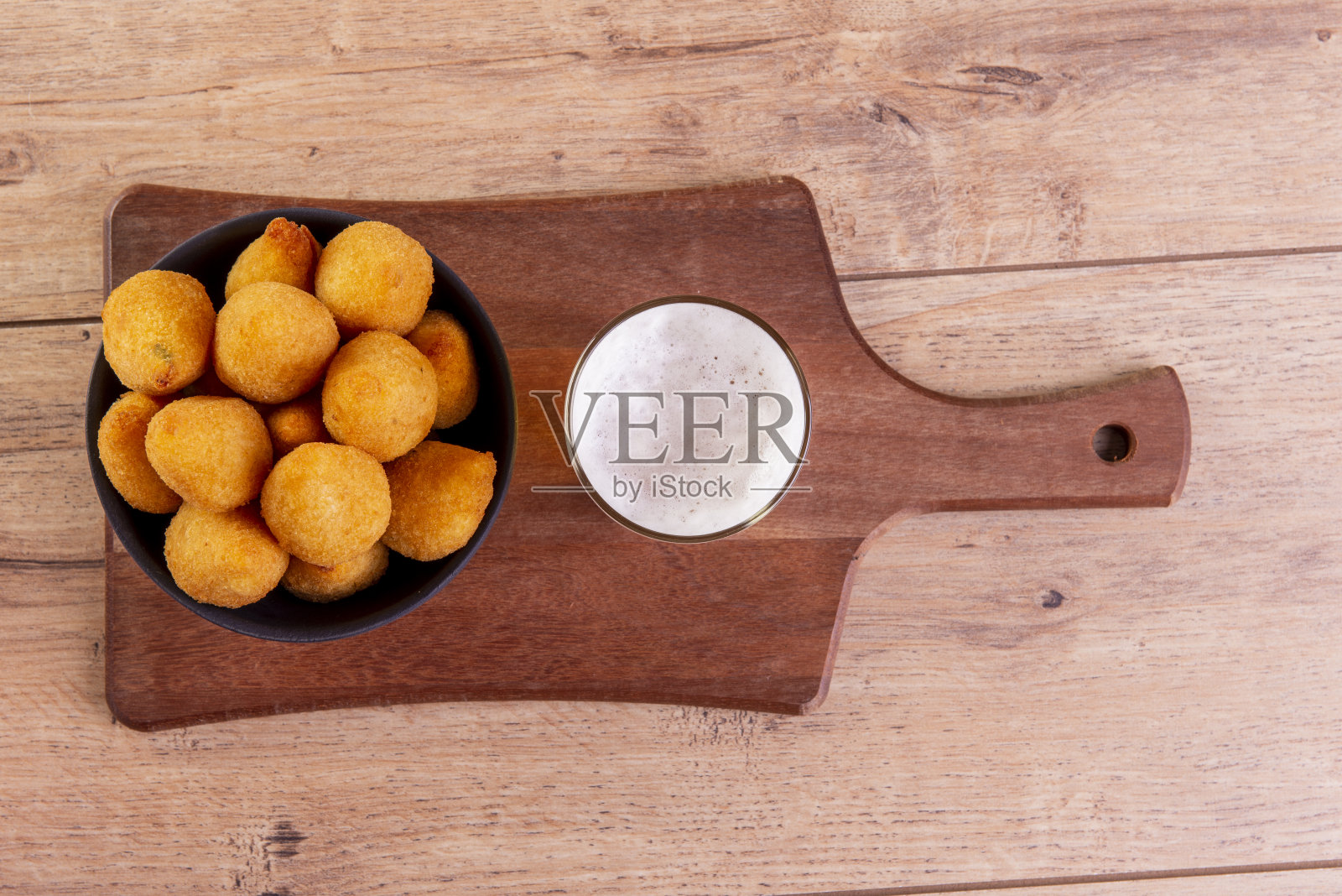 传统的巴西油炸小吃,用名为“coxinha”的鸡肉和一杯啤酒制成照片摄影图片