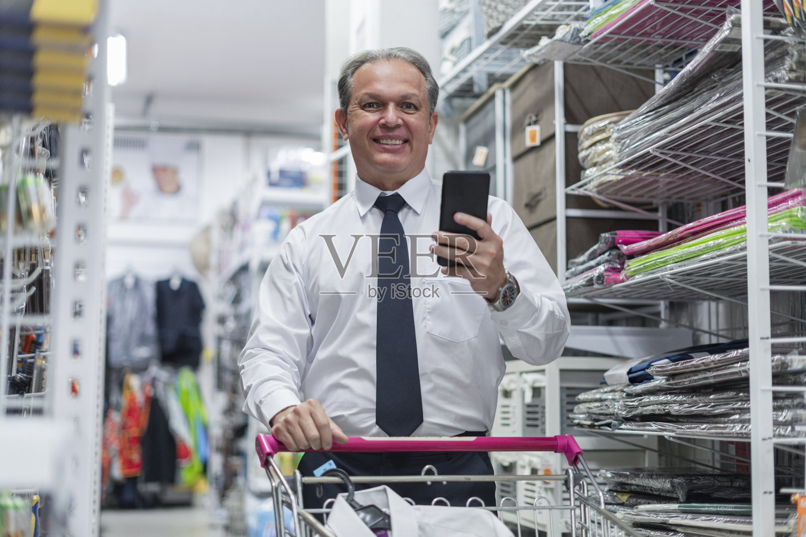 一名员工的肖像,展示他的手机自豪地说,他的工作做得很好,而戴着他的面具照片摄影图片