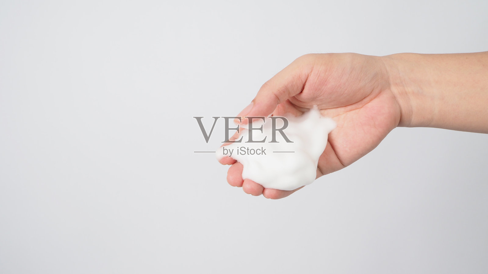 在白色背景上用起泡肥皂洗手。照片摄影图片