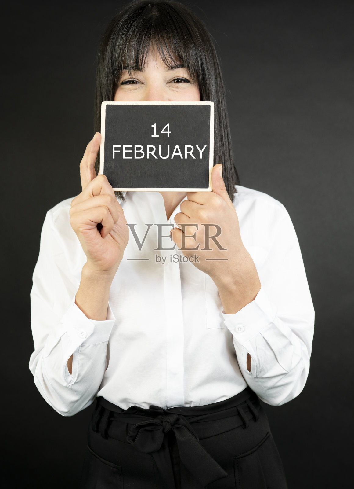 商业妇女拿着一块白板写着2月14日的字照片摄影图片