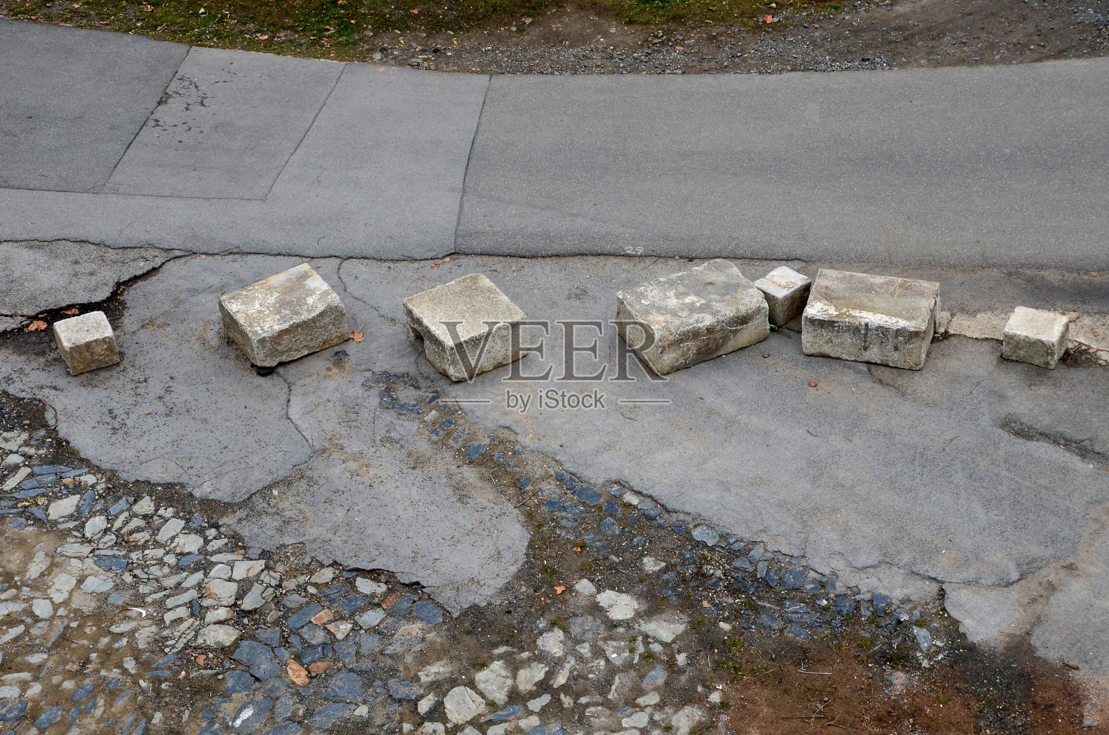 进入战区的汽车的临时屏障,在州边界的一条裂缝道路上,有大小不一的不规则混凝土块,保护着警察和士兵照片摄影图片