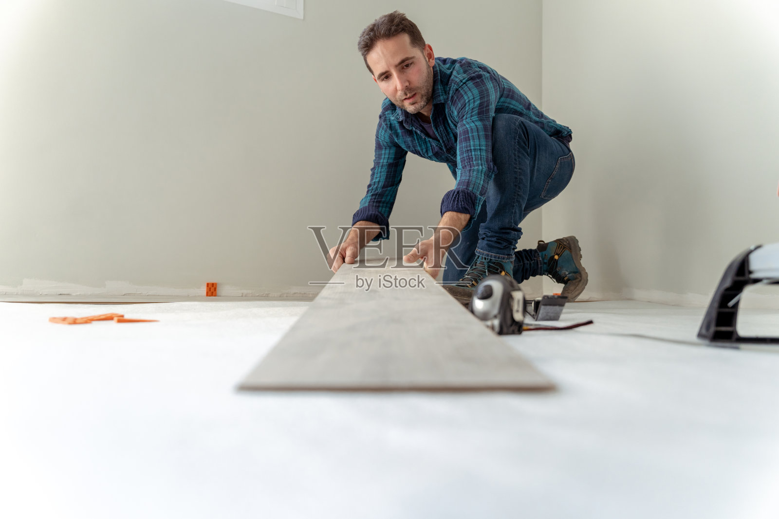 一个男人的特写,拿着一块木头来安装房子的地板照片摄影图片