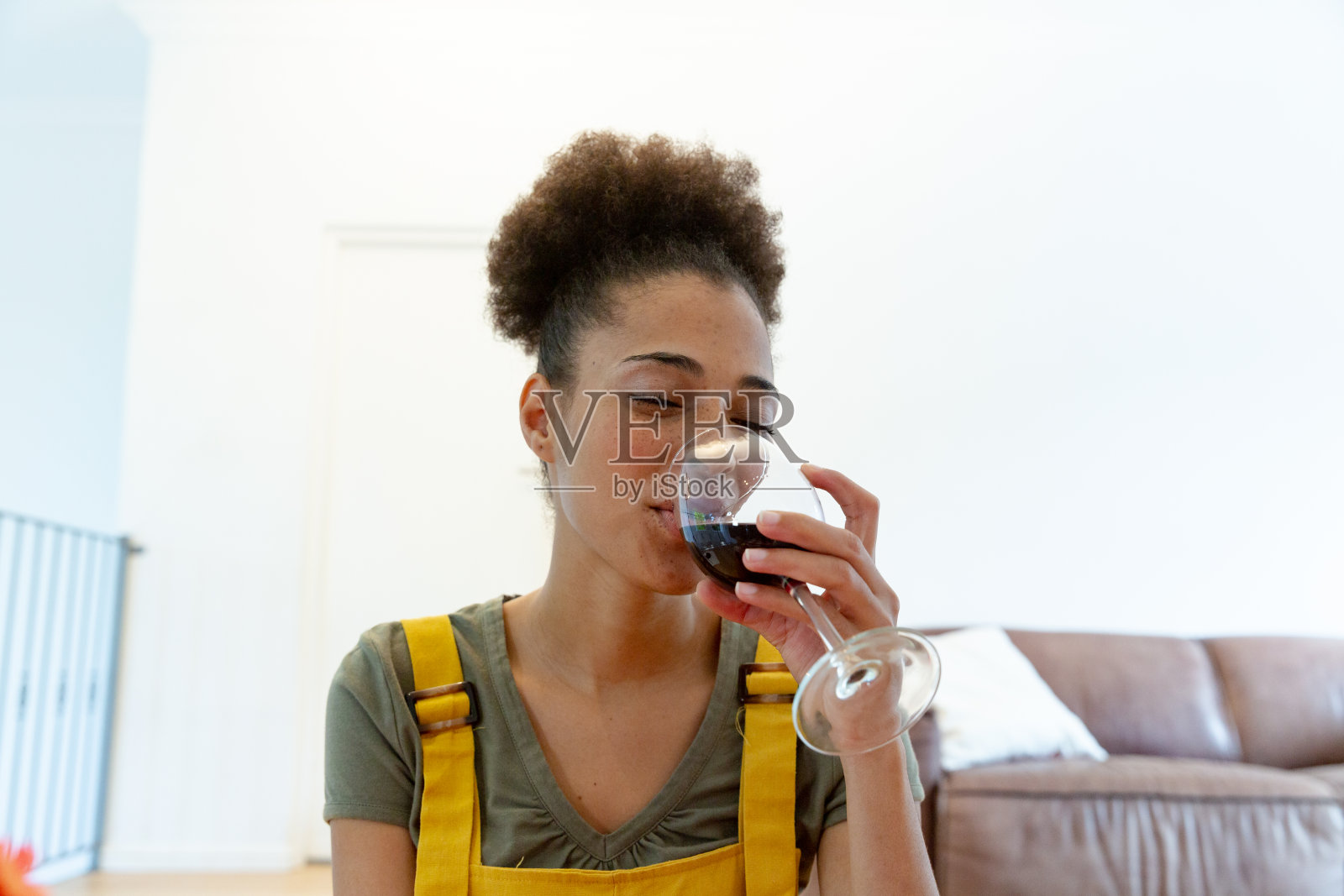 混血女人喝着酒在家微笑照片摄影图片