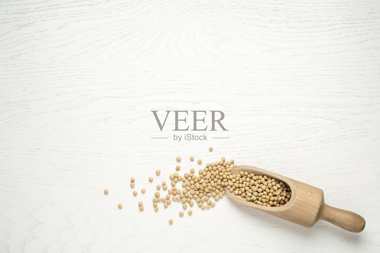 白色木桌上放着大豆和勺子,俯视图。空间的文本照片摄影图片