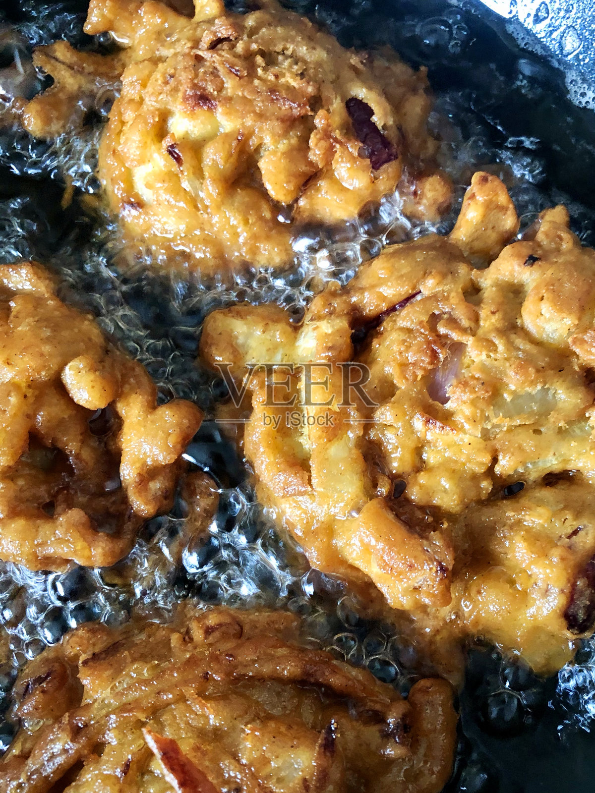 想象自制的酥脆洋葱bhajis / babajees在热冒泡,烹饪油,印度菜素食小吃,高视阔视照片摄影图片
