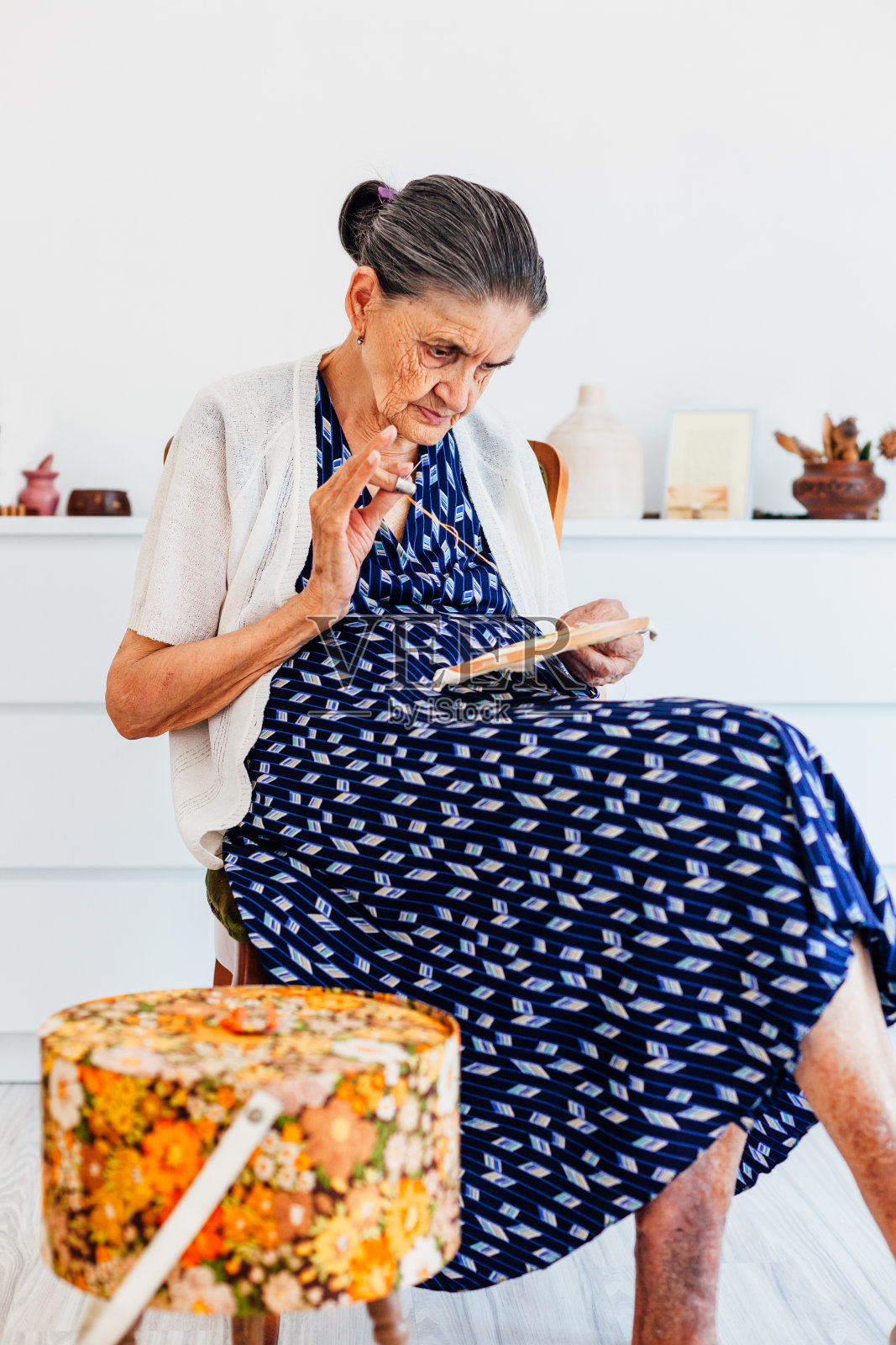 老妇人坐着缝纫,却不戴眼镜照片摄影图片