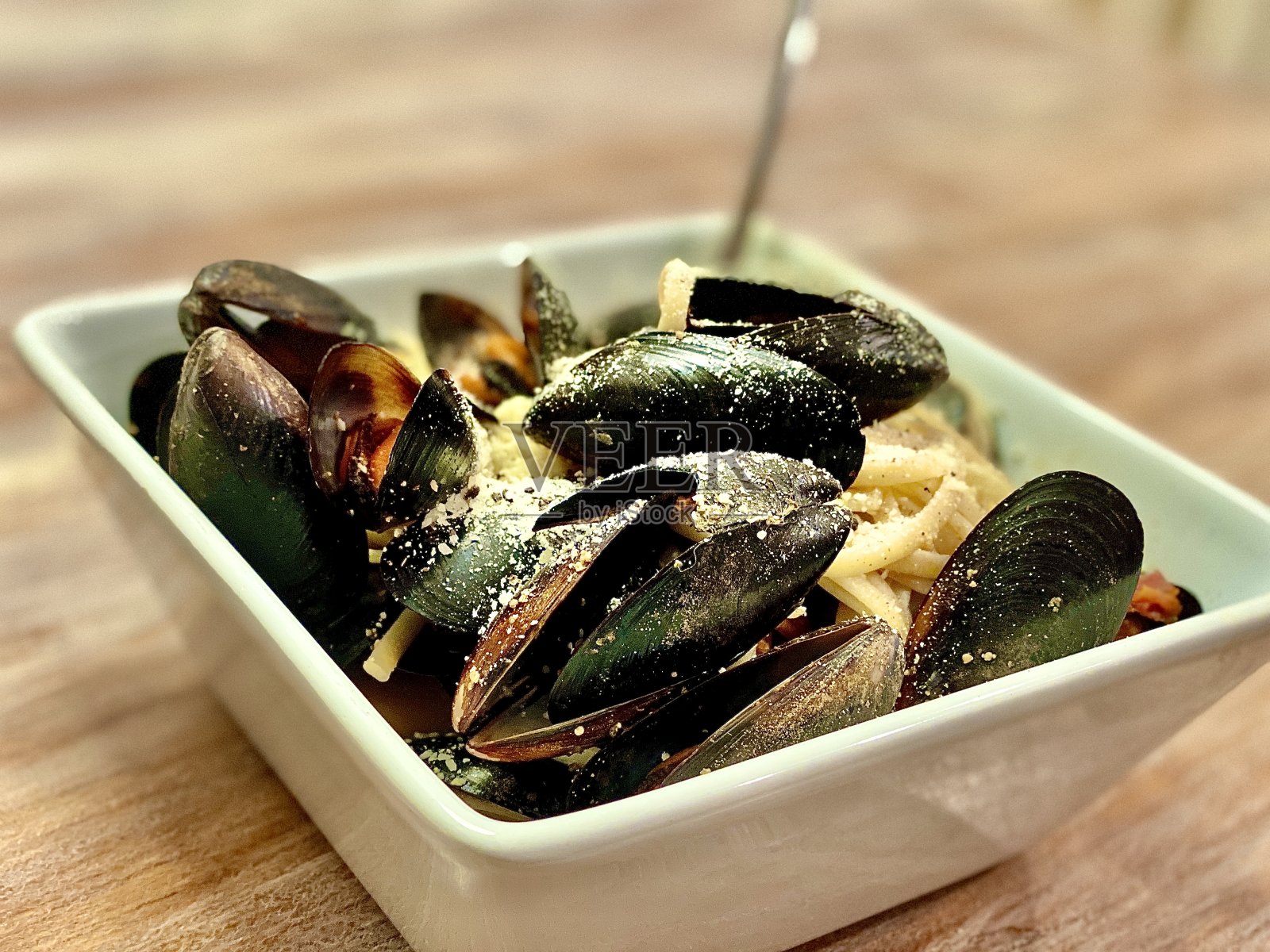 意大利宽面配清蒸贻贝,配酒汁。照片摄影图片