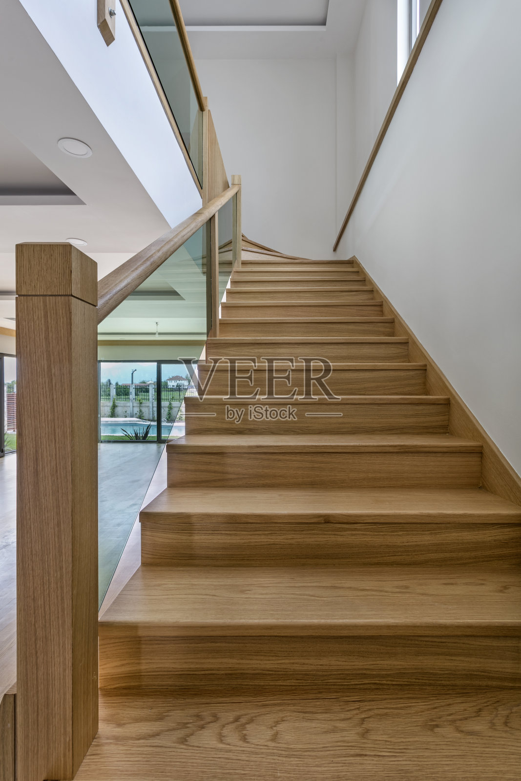 带有玻璃栏杆和木制扶手的木制楼梯照片摄影图片