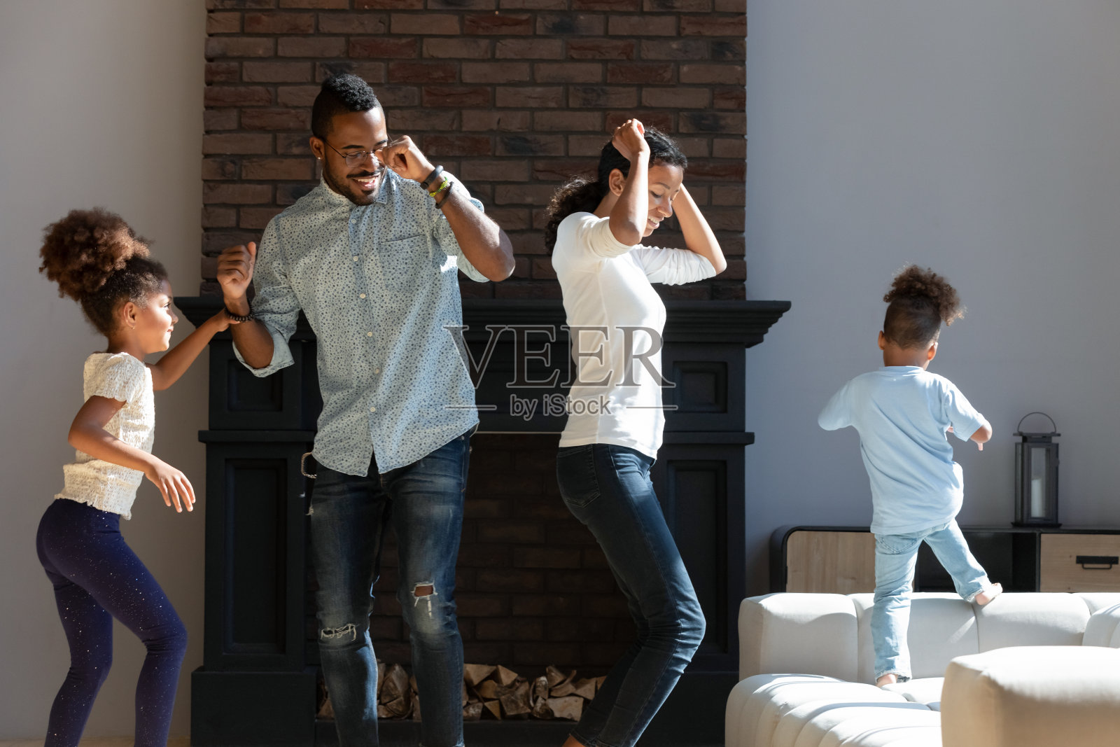 幸福的非裔美国夫妇和两个在家里跳舞的孩子照片摄影图片