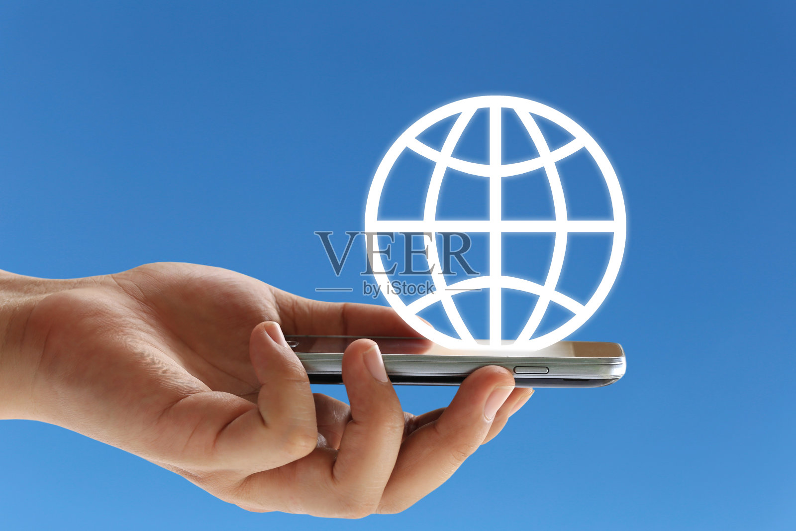 一个商人的手拿着智能手机,蓝色背景上有世界标志。照片摄影图片