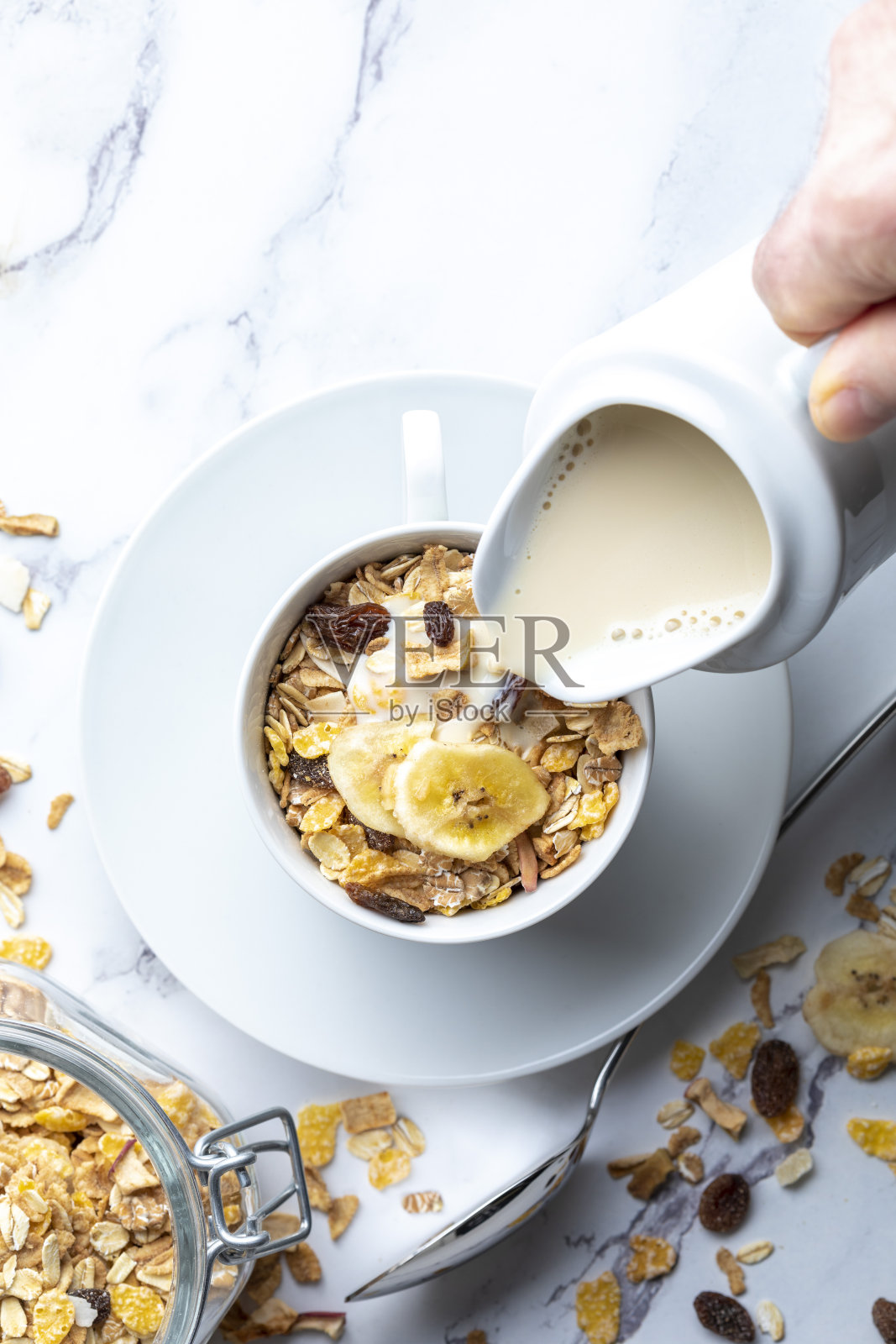 牛奶碗和全谷物早餐麦片和一壶牛奶。什锦麦片和干果。与复制空间。在光的背景。照片摄影图片