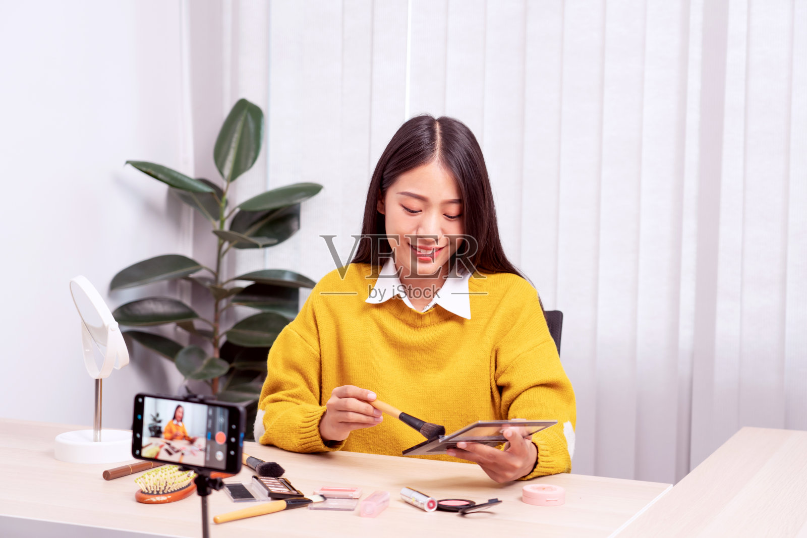 亚洲女性在家通过互联网向社交网络展示美容化妆品并直播视频,以美容博客为理念照片摄影图片