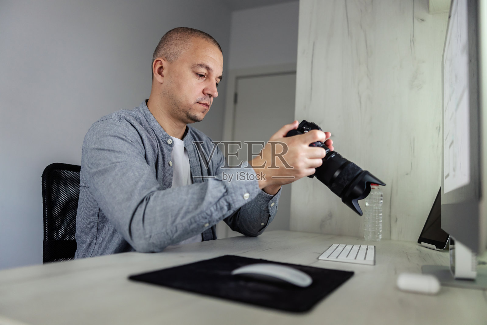 摄影师的一个工作日。一位经验丰富的摄影师用他拍摄照片时制作的镜头在一个红色的相机上观察原材料。照片爱好者,自由的创意精神照片摄影图片