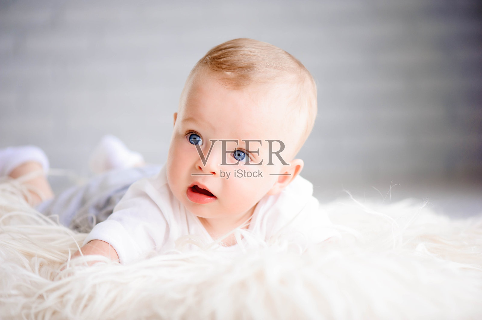 可爱的小男孩学习爬和玩在白色阳光b照片摄影图片