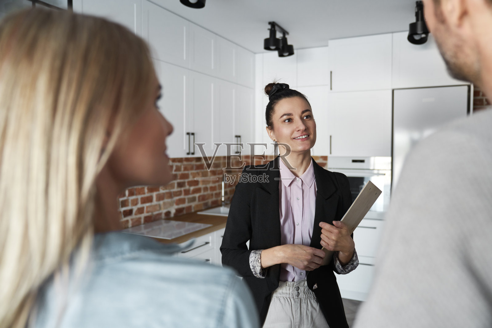 房地产经纪人给一对夫妇看新公寓照片摄影图片