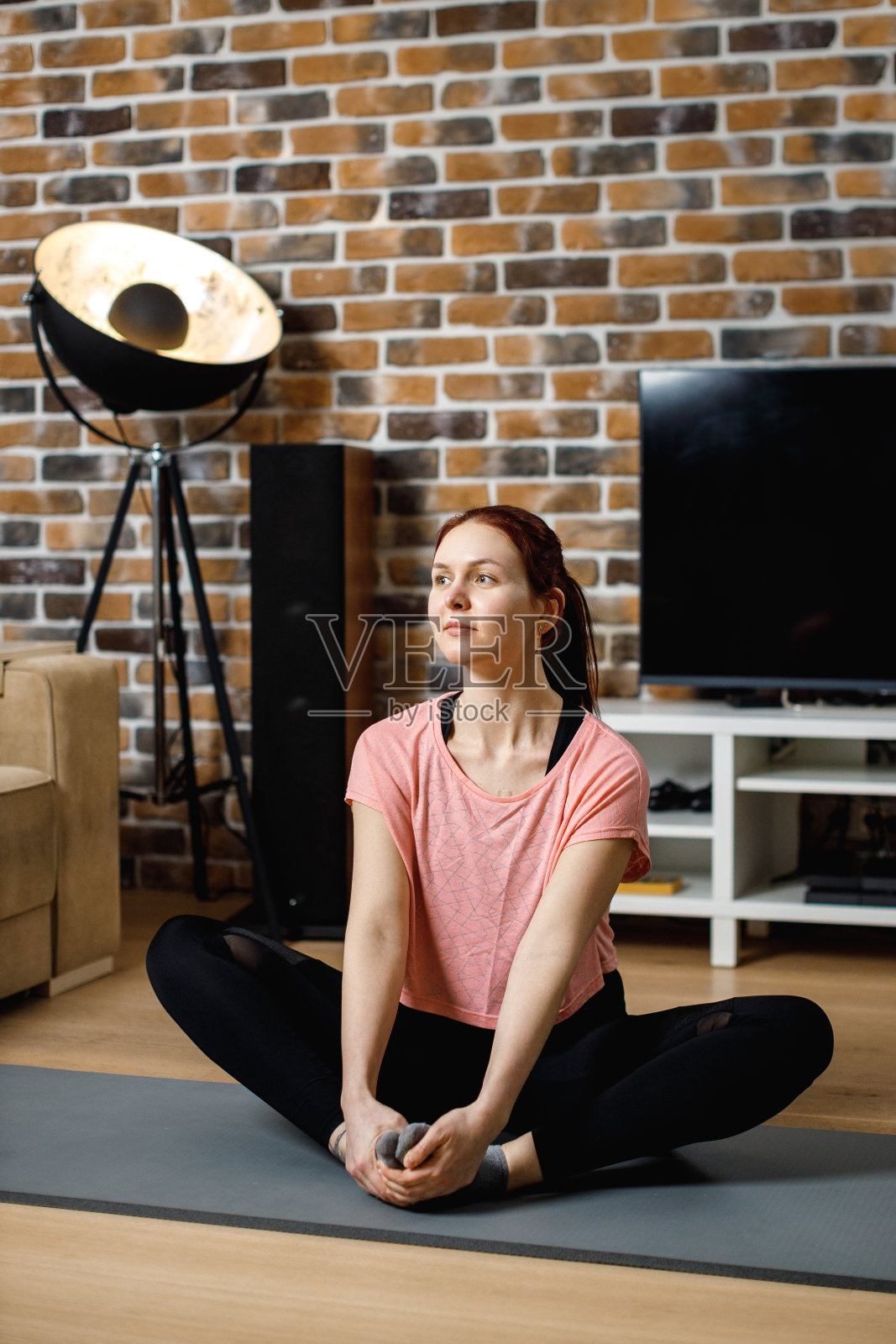 平静的女人沉思,聆听灵性练习课程,坐在莲花坐姿在家。瑜伽的概念。照片摄影图片
