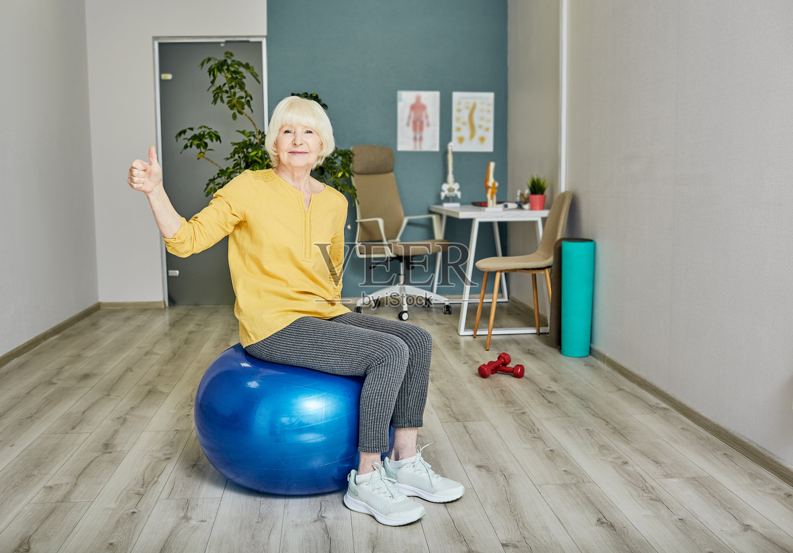 一位年长女性在健身中心训练时竖起大拇指照片摄影图片