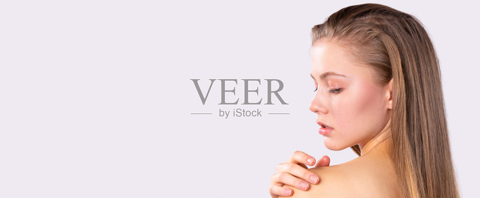 横幅,长格式的灰色背景。后视图,照片中的年轻苗条的女人在空旷的地方看着远方。女性放松。水疗、健康、皮肤和身体护理理念照片摄影图片