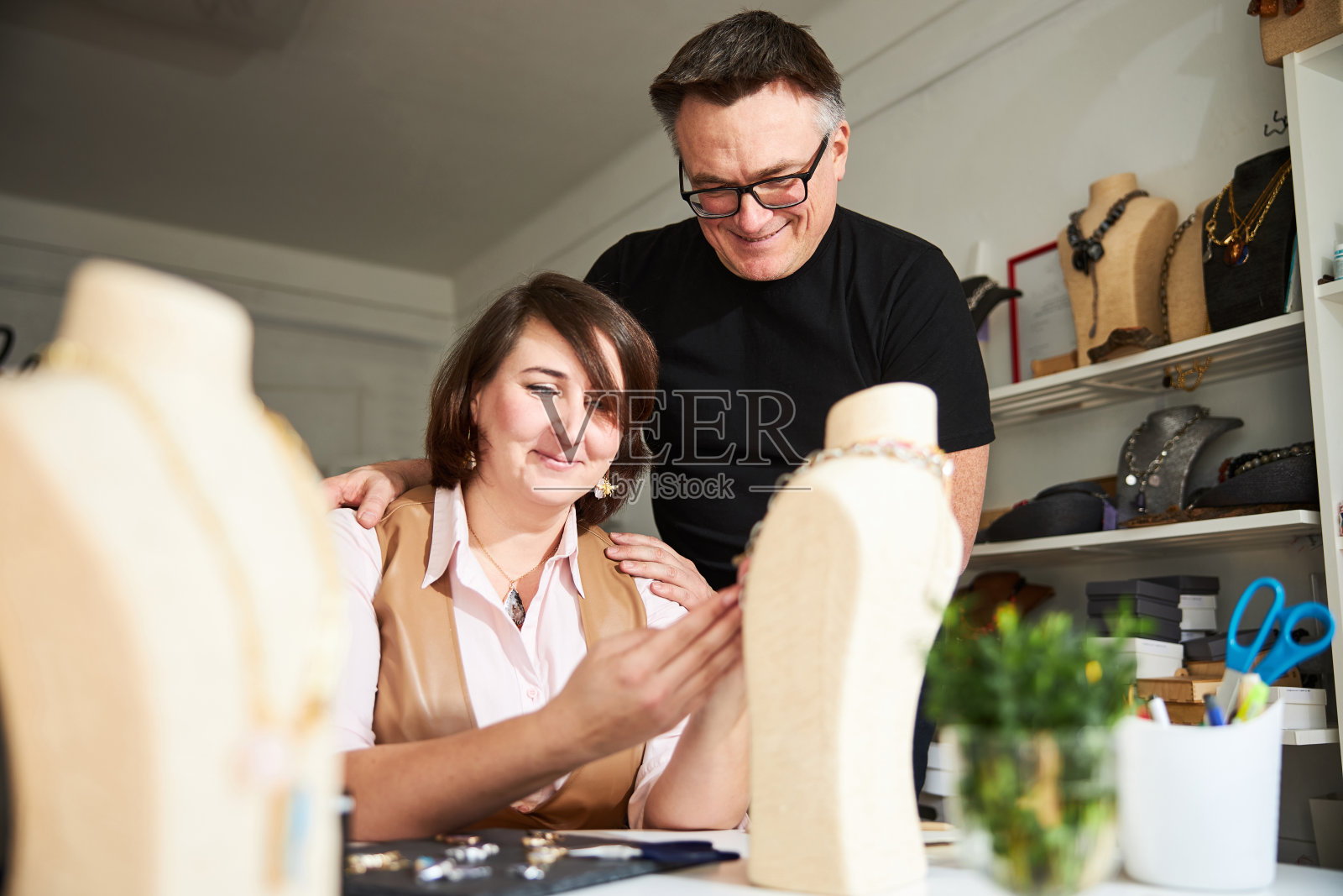 两个珠宝商正在看展示的半身像上的吊坠照片摄影图片