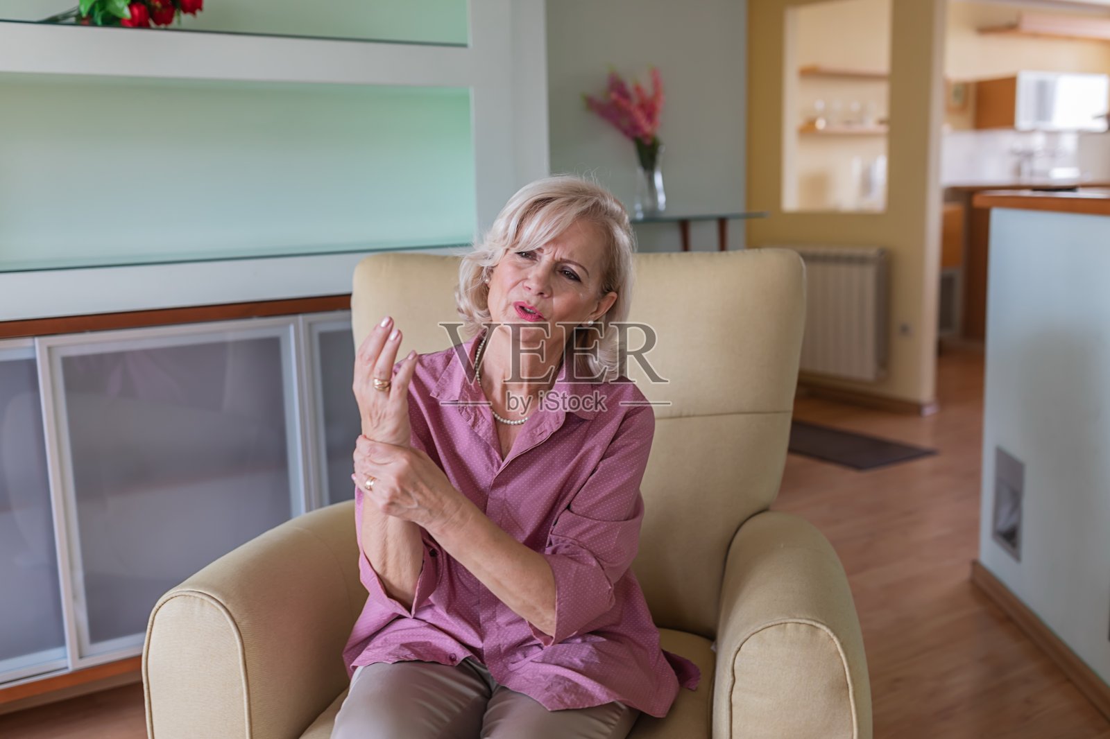 老妇人坐在家里,手腕疼痛难忍照片摄影图片
