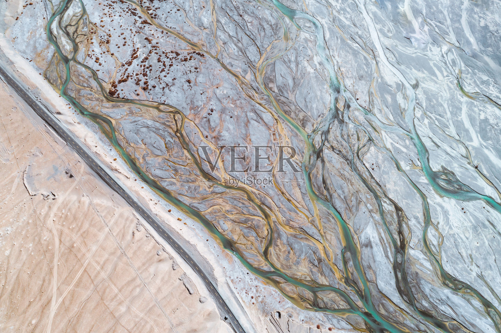 青藏高原上一条经过干涸河床的路照片摄影图片