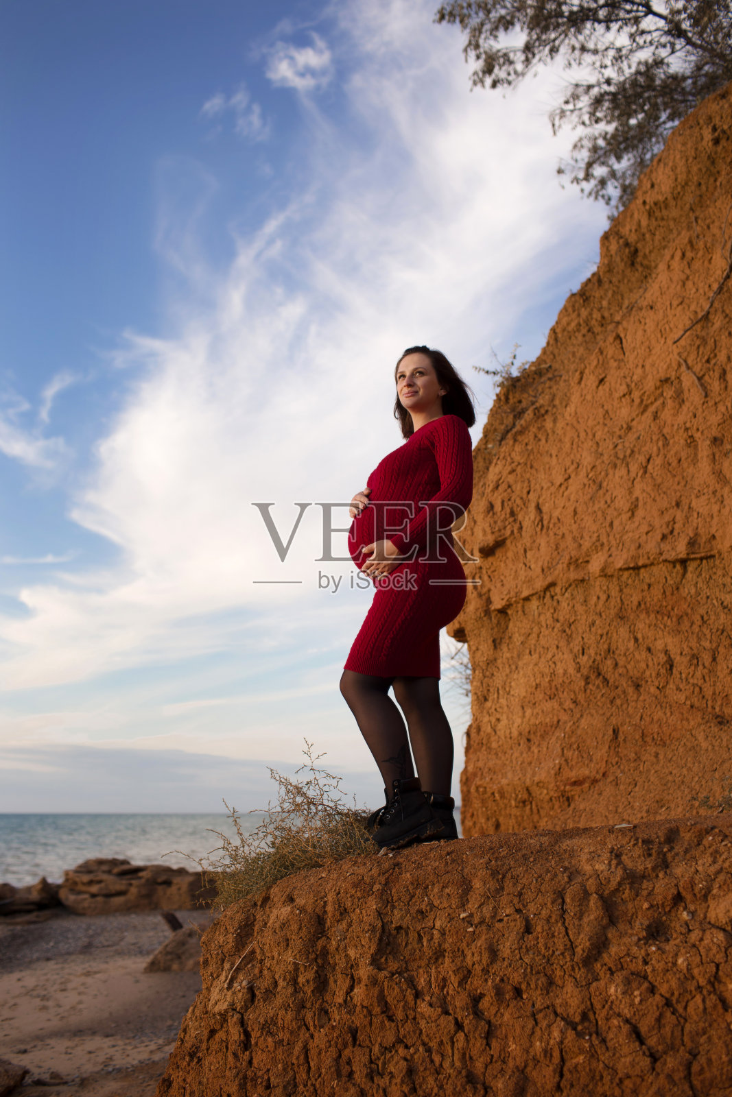 时尚孕妇。美丽的年轻孕妇在欣赏日落。怀孕的肚子。照片摄影图片