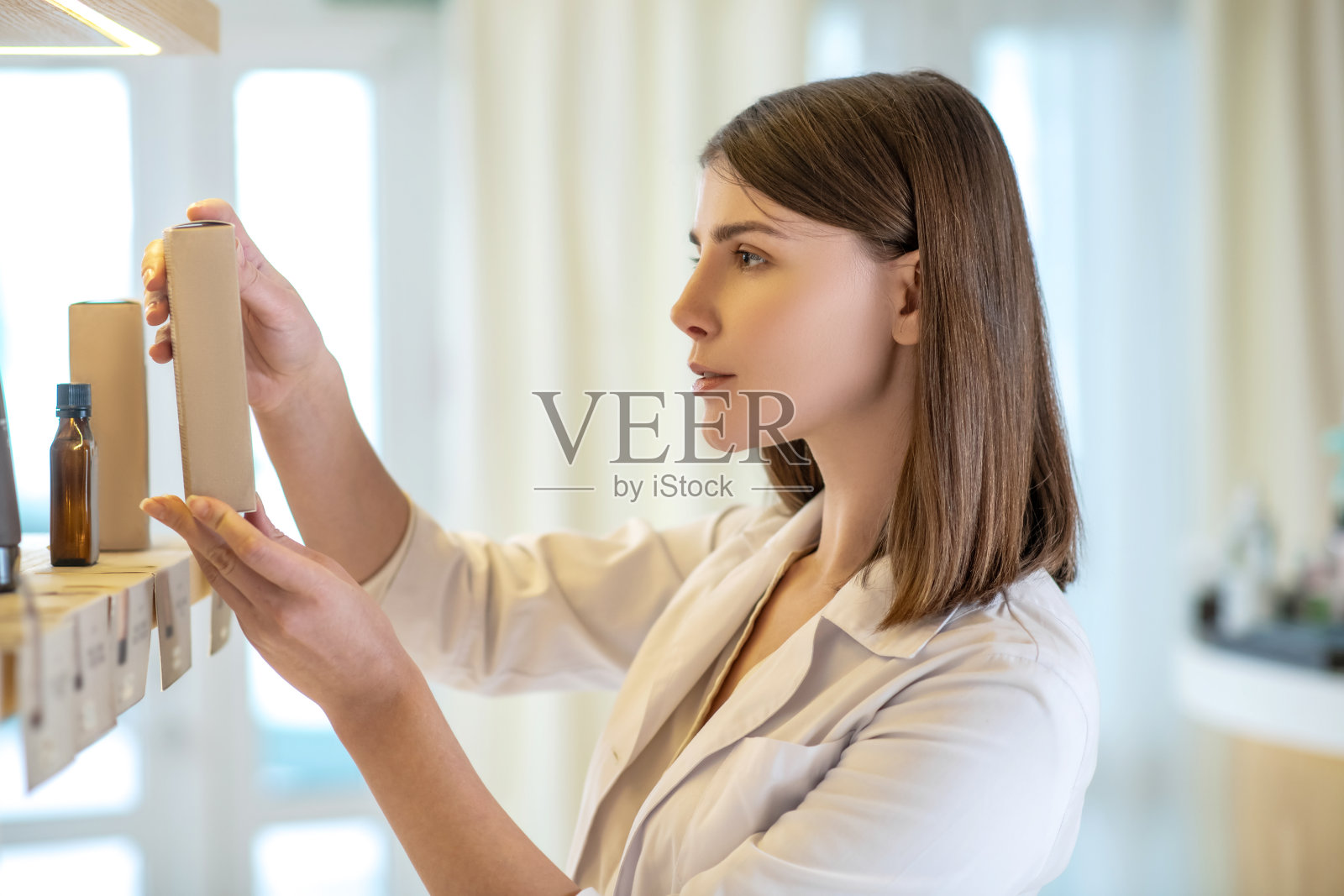 漂亮的店员检查新产品和看起来参与照片摄影图片