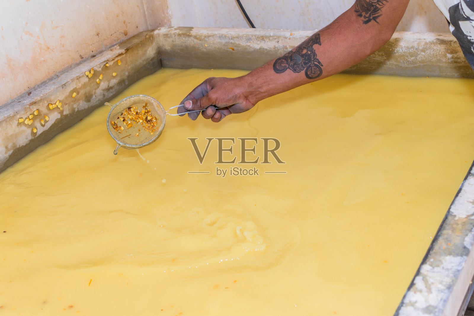 男子用手用滤网清洗煮熟玉米后的水照片摄影图片