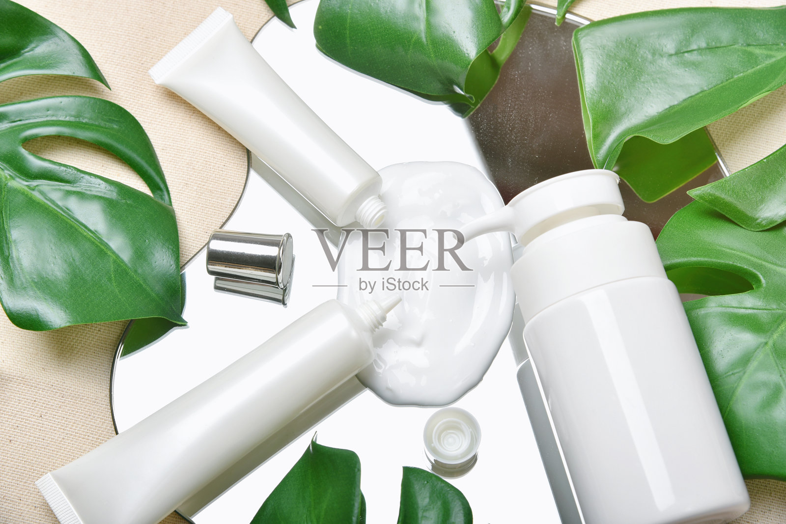 天然护肤美容产品与霜的纹理,化妆品瓶容器包装与绿色的自然树叶,空白标签的有机水疗品牌模型,草药健康的皮肤护理。照片摄影图片