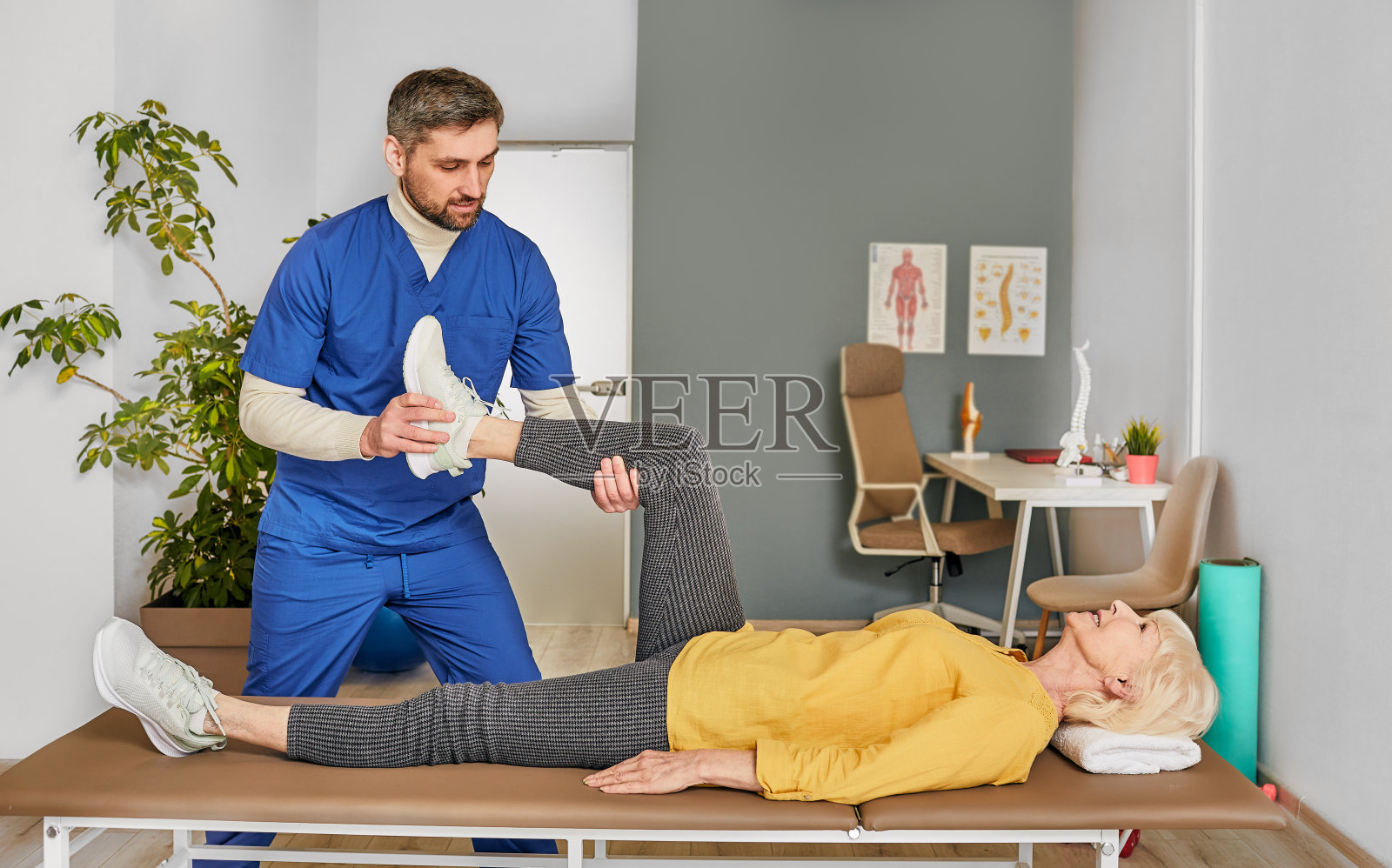 帮助老年妇女在膝盖受伤后做腿部锻炼的理疗师照片摄影图片