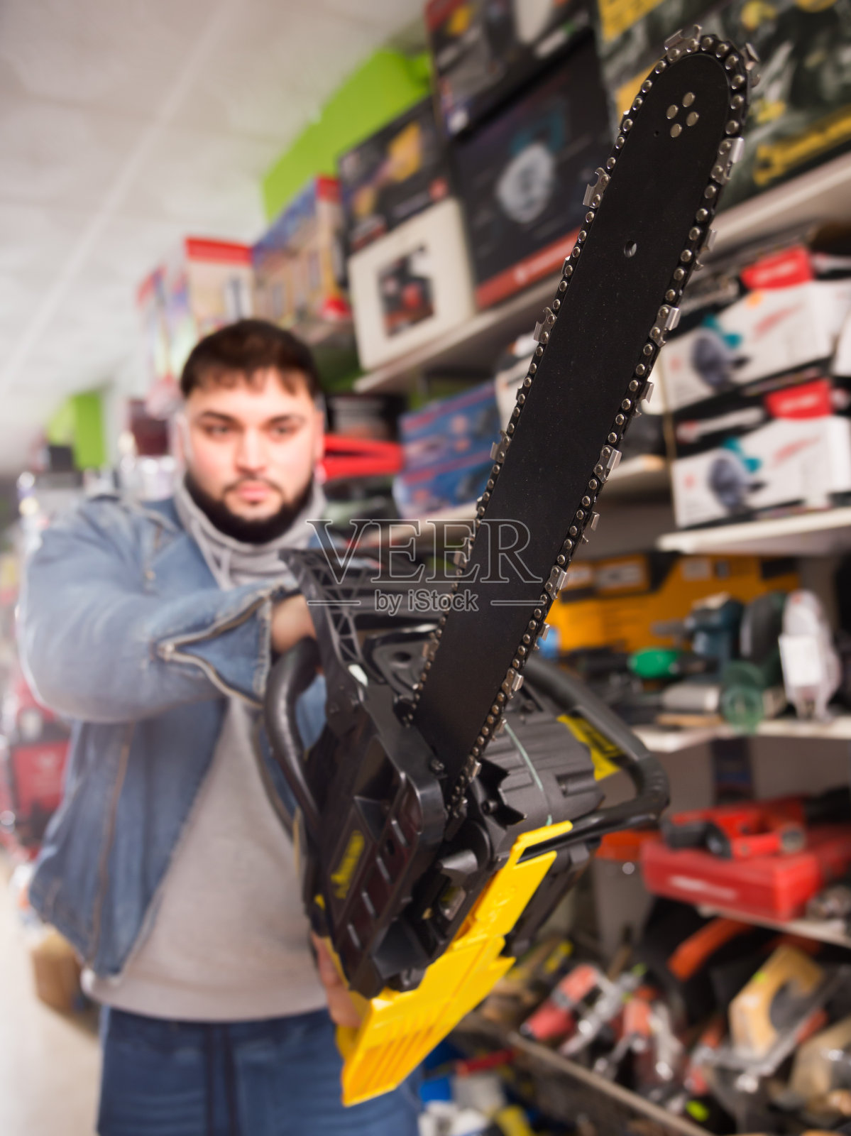 一个专注的人正在买新的电锯照片摄影图片