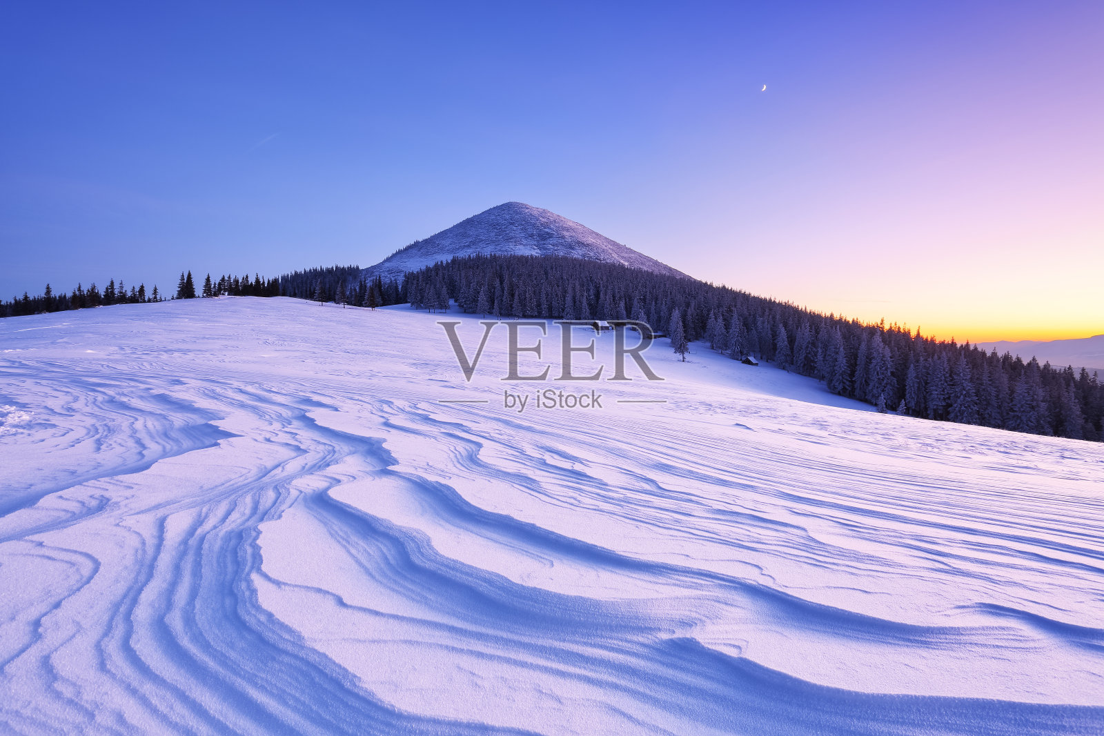 冬季森林。很棒的日出。高山和雪白的山峰。雪堆上覆盖着霜冻的树木的全景。自然景观与美丽的天空。地球的复兴。照片摄影图片